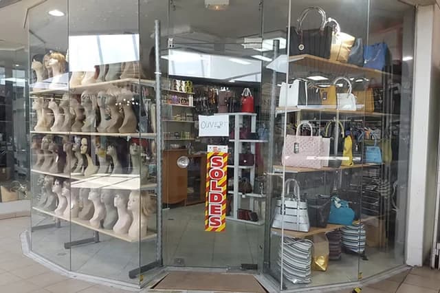 La vitrine de la boutique Coco Tchou : perruques sur mannequins et sacs à main